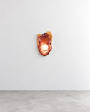 Sculptural Lotus floor lamp featuring layered orange petal-shaped elements, a slender pink stem, and a purple base. Its floral-inspired silhouette combines expressive color with contemporary decorative lighting design.