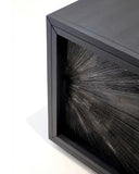 Corner detail of the Black Sun Hole cabinet highlighting its handcrafted frame and textured radial surface treatment
