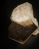 Ialino sculptural coffee table featuring a raw quartz crystal base and angular metal tabletop