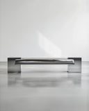 Sculptural bench crafted from polished stainless steel. A designer seating piece featuring a reflective contemporary silhouette.