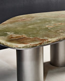 ONI coffee table showcasing the richly veined onyx surface and brushed metal cylindrical legs. A sculptural designer coffee table for sophisticated modern spaces.