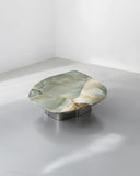 Sculptural round coffee table featuring a natural stone top. A designer centre table inspired by organic forms and materials.