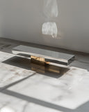 Architectural bench with sculptural intersecting base and minimalist profile. Collectible design furniture that combines function with artistic expression.