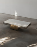 Sculptural coffee table featuring a stone top and metal pedestal base. A designer centre table with contemporary architectural character.