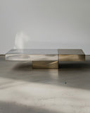 Sculptural coffee table combining natural stone and polished metal. A designer centre table inspired by architectural forms.