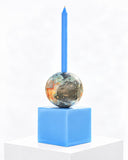 Adrian Cruz Pianeta Blue candle holder featuring a vivid blue cubic base, a multicoloured spherical centre, and a slender blue candle stem. Its playful geometric forms and contrasting colours create a sculptural decorative accent for contemporary interiors.