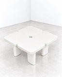 Alentes Atelier Leaf Table IV featuring four softly rounded, square tabletop sections arranged in a compact modular composition, supported by chunky cylindrical legs. Its clean ivory finish and rounded geometry create a sculptural contemporary table.