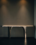 Sculptural console table featuring a stone-inspired finish and architectural silhouette. A designer console table crafted for contemporary luxury interiors.