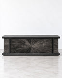 Alex Turco Black Sun Hole Cabinet featuring a dark rectangular body with a dramatic radial sunburst pattern across its front panels. Its bold geometric detailing and monochromatic finish create a striking contemporary storage statement.