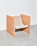 ADRI chair in Travertine showcasing textured stone panels and a sculptural upholstered seat. A statement designer chair for luxury residential and hospitality spaces.