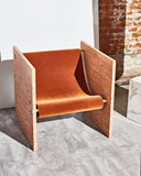 Travertine designer chair featuring distinctive stone side panels, sculptural upholstery and brass detailing. Crafted as a bold contemporary seating piece.