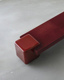 Close-up of the Coexist Oxblood bench showcasing its rounded support and deep red sculptural seat. The bold geometric design creates a distinctive statement for modern interiors.