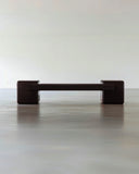 Coexist RedUx Ebony designer bench featuring a sculptural black seat and rounded geometric supports. A statement bench for contemporary luxury interiors.