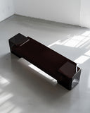 Arielle Assouline Coexist RedUx bench in Ebony with a long sculptural seat and rounded end supports. A contemporary designer bench for sophisticated residential and hospitality spaces.