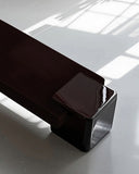 Close-up of the Coexist RedUx Ebony bench showcasing its rounded support and sculptural black seat. The bold geometric design creates a distinctive statement for modern interiors.