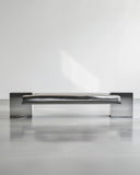 Sculptural bench crafted from polished stainless steel. A designer seating piece featuring a reflective contemporary silhouette.