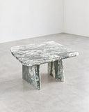 Sculptural Lino coffee table featuring a pale, richly veined stone top and substantial textured stone supports. The natural surface variation gives this contemporary coffee table a distinctive material presence.