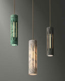 Three cylindrical pendant lights with marble-like finishes on a gray background. AURA Pendant | Modern Designer Lighting