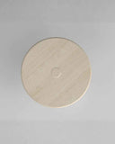 Round beige stone object on a gray background. STILO Classic Travertine | Designer Dining Table