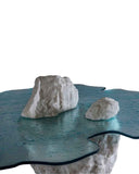 Designer glass coffee table with artistic sculptural detailing. A statement piece for luxury living spaces.