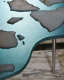 Sculptural dining table featuring layered glass detailing. Designed for contemporary residential and hospitality spaces.