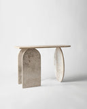 Sculptural travertine console table inspired by classical architecture. A designer console featuring monolithic stone forms.
