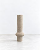 Genaro Hoepfner RO07 Ceramic Object featuring an elongated cylindrical form with a rounded central protrusion and a softly textured beige finish. Its restrained palette and sculptural geometry bring understated character to contemporary interiors.