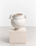IAMMI Champion Size M is a sculptural ivory vessel featuring a rounded body, short neck, and distinctive geometric side handles. Its glossy finish and balanced proportions give this decorative object a contemporary interpretation of a classic urn.