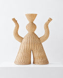 Chaan Maak fiber sculpture featuring an expressive, symmetrical figure with raised curved arms and a flared woven headdress. The natural fiber construction highlights intricate texture and artisanal craftsmanship.