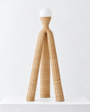 LS-16 floor lamp featuring a tall, tripod-like woven fiber structure and a rounded white lampshade. The sculptural silhouette combines natural material texture with minimalist contemporary lighting design.