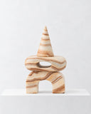 LS-01 pink marble sculpture featuring stacked rounded forms, a pointed conical top, and a compact arched base. The natural stone veining and playful geometry create a distinctive collectible design object.