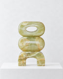 LS-02 green marble sculpture featuring stacked rounded geometric forms with a central opening and arched base. The translucent-looking green veining and polished surface emphasize the natural beauty of the stone.