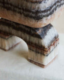 Luxury marble accent table featuring natural brown stone veining and a sculptural silhouette. Designed to bring warmth and sophistication to contemporary spaces.