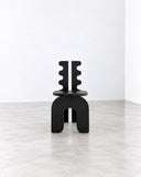 METAMO Marte Chair featuring a bold black sculptural frame with distinctive scalloped vertical supports and a compact rounded seat. Its architectural silhouette and contrasting cutout details create a striking contemporary accent chair.