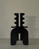Sculptural dining chair crafted from solid wood. A designer chair featuring bold architectural detailing.