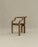 Sculptural wooden chair with flowing organic armrests. A designer seating piece crafted from solid timber.