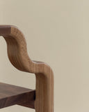 Sculptural timber chair celebrating natural materials and craftsmanship. Designed for sophisticated residential spaces.