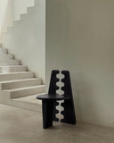 Luxury wooden chair with a sculptural geometric profile. Designed for sophisticated dining environments.