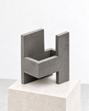Paolo Giordano Chandigarh IV sculptural seat featuring a geometric, open-sided form with thick angular panels in a textured grey finish. Its architectural silhouette combines functional proportions with a bold contemporary aesthetic.
