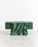 Paolo Giordano Venus Marble Bench featuring a long rectangular green marble seat with a dramatic, flowing sculptural base. Its rich green veining and draped, organic form create a distinctive statement piece for luxury residential and hospitality interiors.