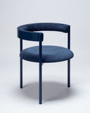 Luxury upholstered chair in dark blue featuring a sculptural contemporary profile. Designed to elevate sophisticated dining and living spaces.