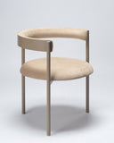 Contemporary upholstered chair in linen-toned fabric with a refined sculptural silhouette. A designer chair combining comfort and architectural design.