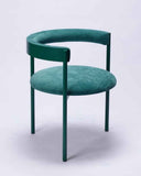 Luxury upholstered chair in Verde Ingles fabric with rounded sculptural lines. Designed as a statement dining chair for contemporary interiors.