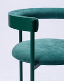 Luxury chair upholstered in Verde Ingles fabric with an architectural silhouette. Designed to complement contemporary dining environments.