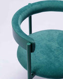 Designer dining chair with plush green upholstery and contemporary sculptural detailing. Crafted to combine comfort with timeless design.