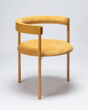 Sculptural upholstered chair in vibrant yellow fabric with a refined contemporary profile. A designer seating piece crafted for luxury interiors.