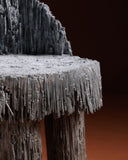 Sculptural dining chair featuring organic forms and handcrafted surfaces. A statement piece for contemporary spaces.