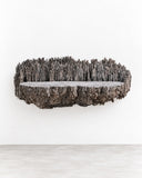 RIES Pasto Shelf III features a long, floating shelf with a rugged, deeply textured dark surface and an irregular sculptural edge. Its bold horizontal form brings an organic, architectural accent to contemporary wall storage.