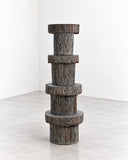 RIES Pasto Totem Fullset features a vertical stack of rounded cylindrical forms with projecting bands and a rugged, dark textured finish. Its totem-like silhouette creates a bold sculptural statement for contemporary spaces.