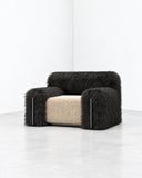 Richard Yasmine Furrybum Black Fur Armchair in a compact, block-like form with plush black fur upholstery and a contrasting tan seat cushion. Its rounded edges and tactile texture give this contemporary lounge chair a distinctive, playful character.